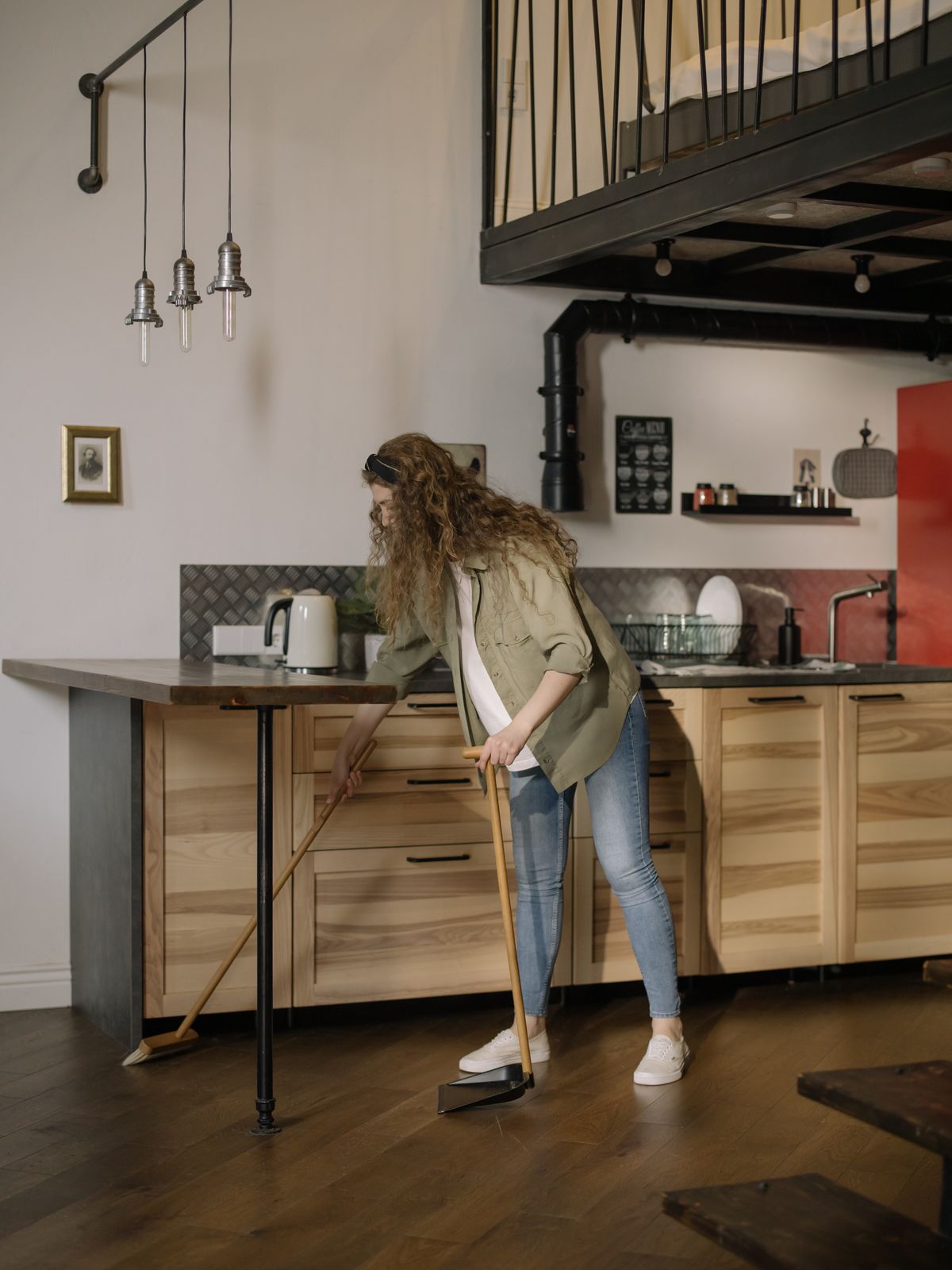 Personne passant le balai dans une cuisine